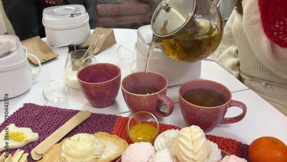Making tea in glass cup with tea strainer on white kitchen table. Close up.