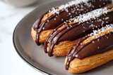 Delicious eclairs with chocolate icing on a white plate.