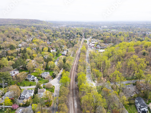 Captured from the skies, this drone image highlights the scenic railway stretching through Millburn, NJ, with the distant NYC skyline creating a striking contrast between urban and suburban landscapes