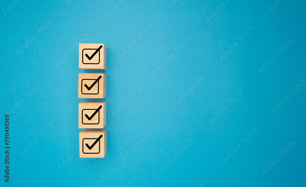 Four correct sign symbols on wooden cubes are over a blue background. Four correct sign symbols on wooden cubes are over a blue background.