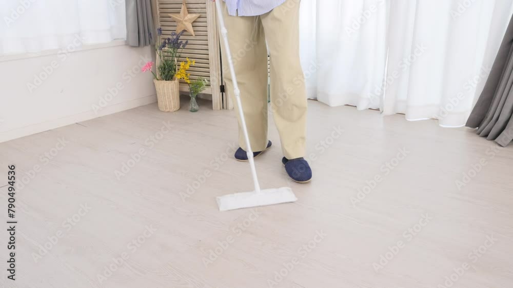 フローリングワイパーで床を掃除する女性　顔なし