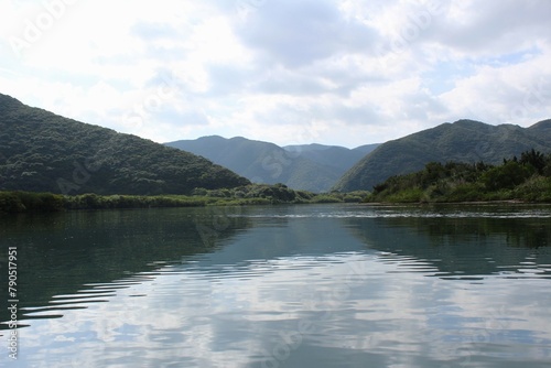 A panoramic view of mountains and dense forests from the river in Amami Oshima Island
