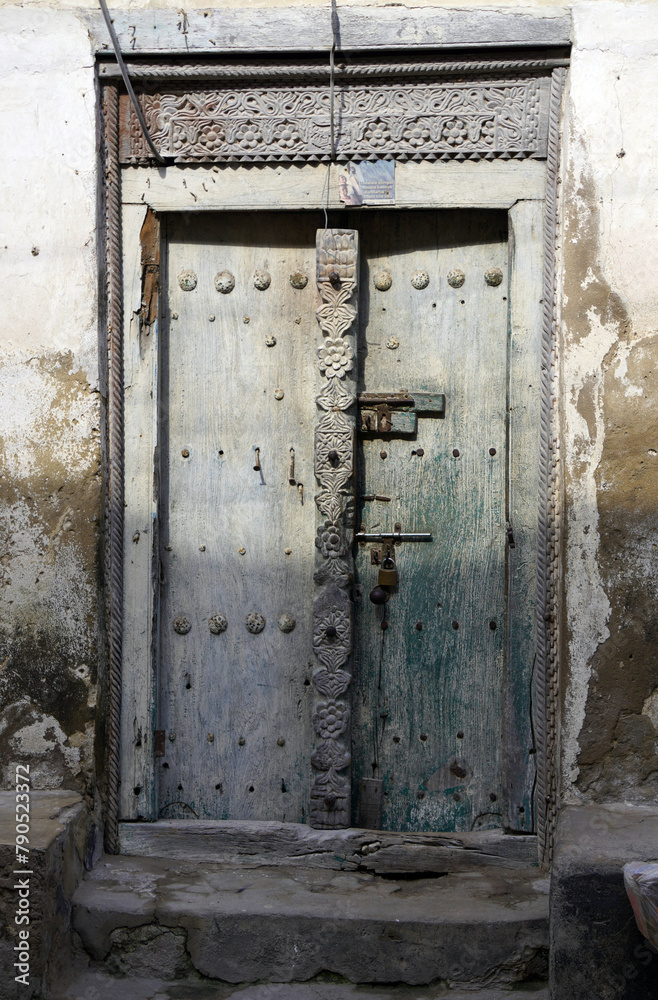 Intricately carved wooden door with metal studs Intricately carved wooden door with metal studs