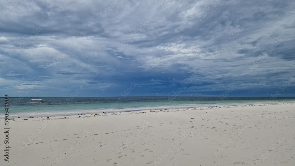 Weißer Sandstrand bei bewölktem Himmel auf Sansibar in Tansania, Afrika