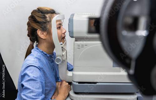 Eye patient woman doing eye testing with machine in optic clinic