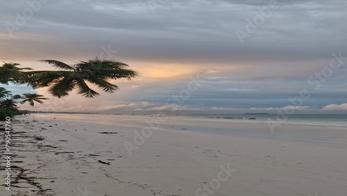 Weißer Sandstrand bei Sonnenaufgang auf Sansibar in Tansania mit bewölktem Himmel