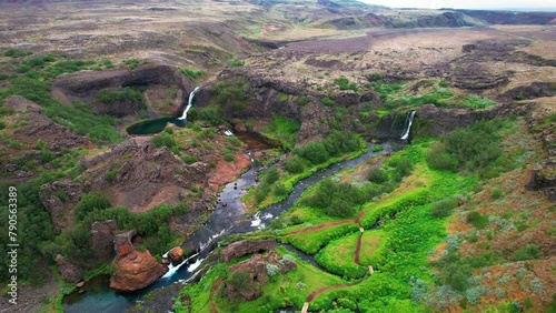 Epic Aerial Iceland Paradise Waterfall Tour Gjain. Drone Flies Over Lush Landscape Two Waterfalls and Rivers. High Quality 4K Color Corrected. photo