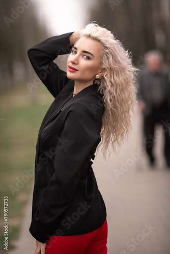 Portrait of a malty beautiful blonde girl on a city street. photo