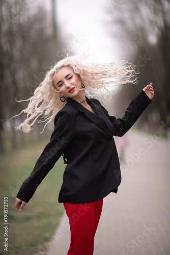 Portrait of a malty beautiful blonde girl on a city street. photo