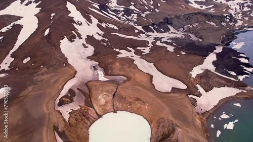 Epic Aerial View of Two Adventure Hikers Walking on Rim of Crater Lake Caldera Iceland Water With Snow and Emerald Pool. In Askja Iceland Region Hikers Are Small in Large Wide View photo