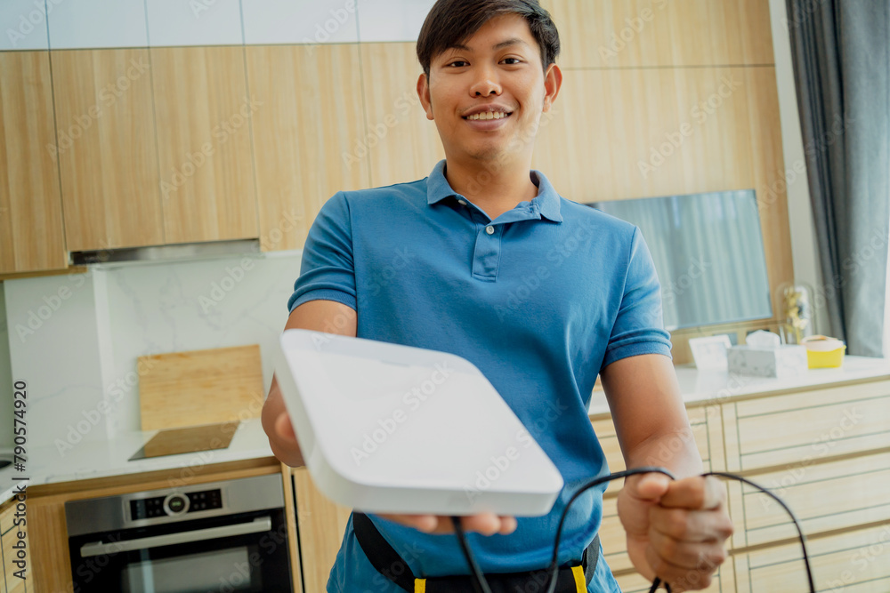 A technician installs a main unit security system in a modern apartment. A technician installs a main unit security system in a modern apartment.