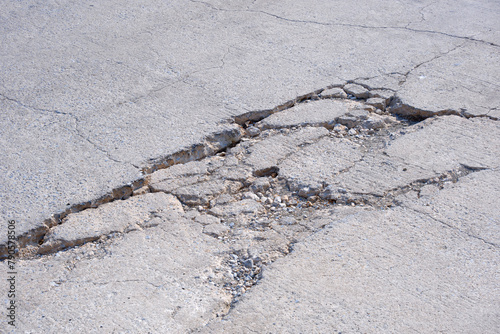 The old badly damaged concrete street background with collapsed and broken crack texture on surface