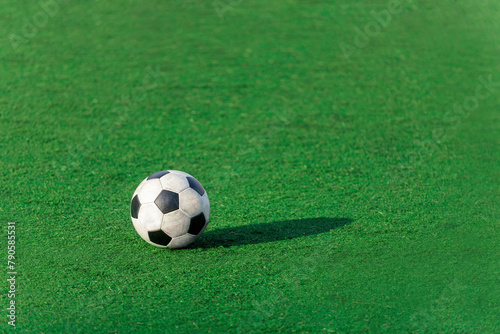 Worn soccer ball on an artificial green field