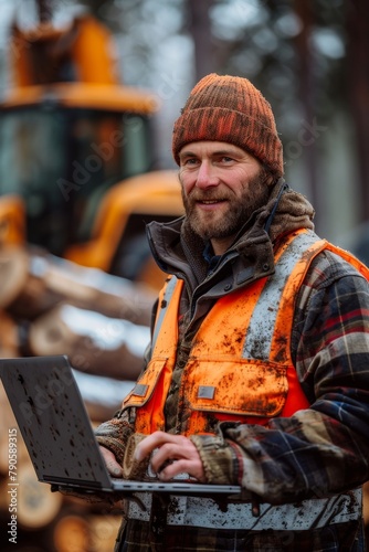 Confident lumberjack with a laptop managing forestry operations