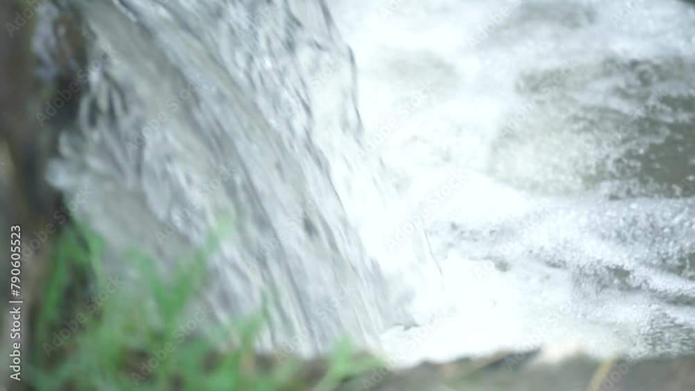 close-up view of the waterfall from rice field irrigation. waterfall that flows into the river close-up view of the waterfall from rice field irrigation. waterfall that flows into the river