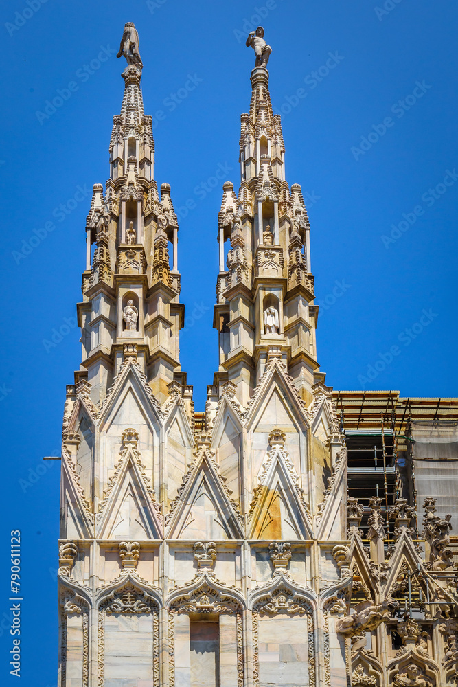 Fototapeta premium Spires of the Cathedral Duomo di Milano, dedicated to St. Mary of the Nativity. Imposing architectural details close-up. View, details, architectures and embellishments.