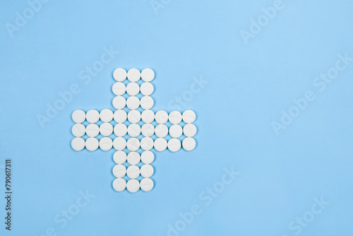 Medical white tablets are laid out in the form of a cross