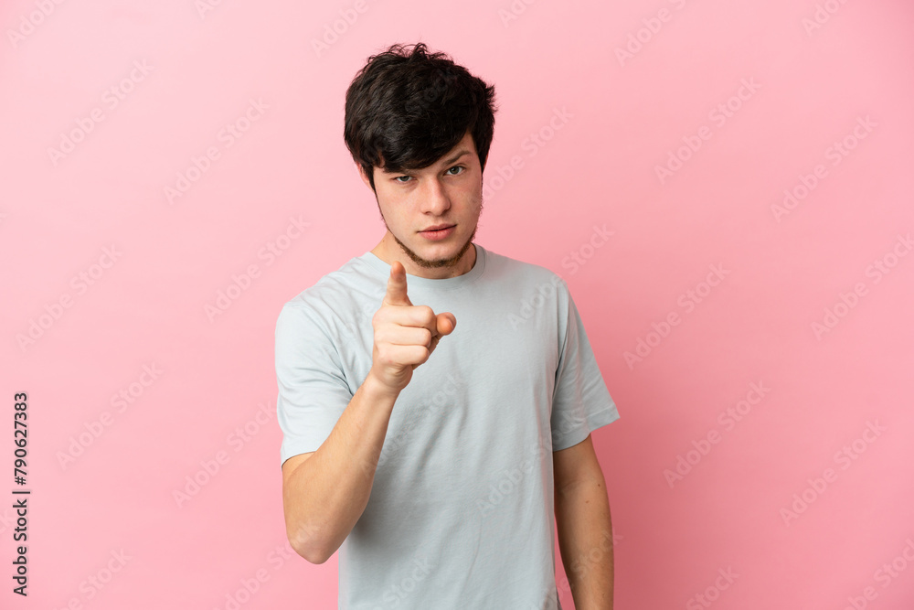 Young Russian man isolated on pink background frustrated and pointing to the front Young Russian man isolated on pink background frustrated and pointing to the front