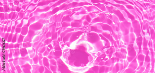 Pink water bubbles on the surface ripples. Defocus blurred transparent pink colored clear calm water surface texture with splash and bubbles. Water waves with shining pattern texture background photo