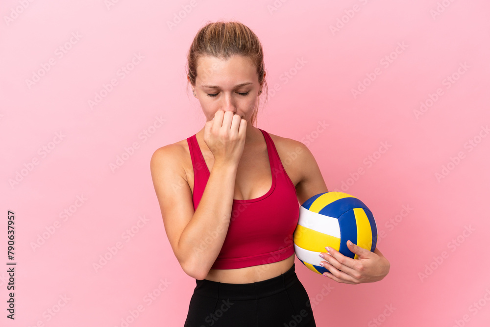 Young caucasian woman playing volleyball isolated on pink background having doubts