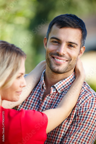 Couple, portrait and outdoor hug in nature, together and love in relationship or bonding in embrace. Happy people, support and marriage on holiday or vacation, relax and commitment or connection © peopleimages.com