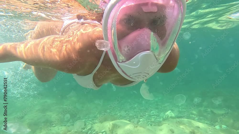 Young happy Woman in white bikini snorkels in the sea with a pink mask. Positive smiling woman relaxing and enjoying water activities with family summer travel holidays vacation on sea.