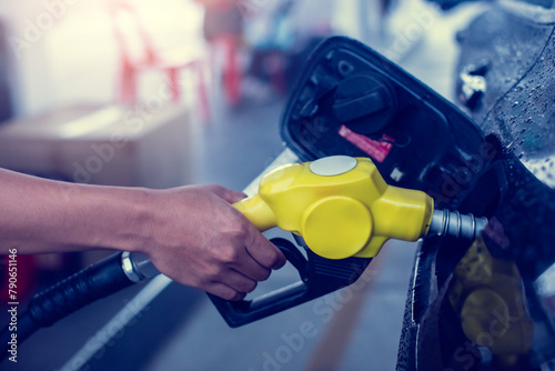 Hand refilling the white pickup truck with fuel at the gas station. Oil and gas energy. Fill a small truck with diesel fuel for transportation.