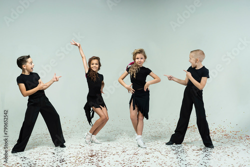 two curly-haired girls and two boys engaged in ballroom dancing show a thumbs up, everything is ok