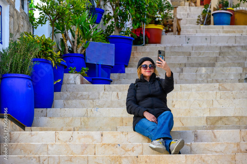 Female tourist taking a selfie in steps of the Holy Cross distri photo