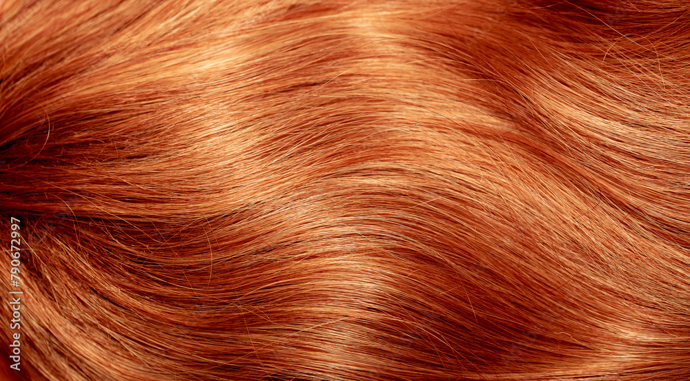 Fototapeta premium Red hair close-up as a background. Women's long orange hair. Beautifully styled wavy shiny curls. Hair coloring bright shades. Hairdressing procedures, extension.