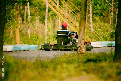 Young Indian man driving go kart on the road in the park.