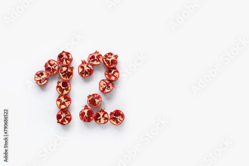 number twelve on white background with red pomegranate