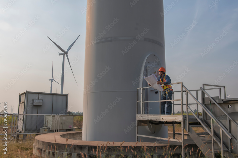 Obraz premium engineers are discussing maintenance of wind turbines. Clean energy. Alternative energy concept. 