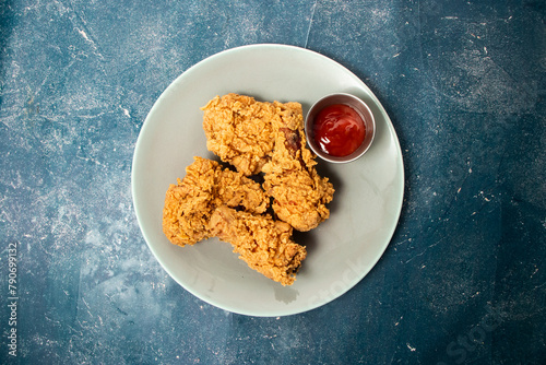 Fried Chicken with ketchup served in plate isolated on background top view of unhealthy fastfood
