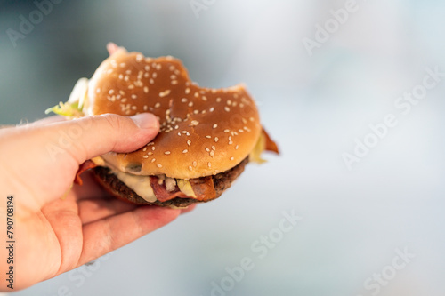 hand holding hamburger in hand. food, eating and health concept.