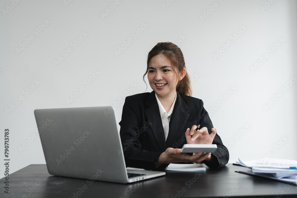 Business woman using calculator and laptop for do math finance on wooden desk in office and business working background, tax, accounting, statistics and analytic research concept Business woman using calculator and laptop for do math finance on wooden desk in office and business working background, tax, accounting, statistics and analytic research concept