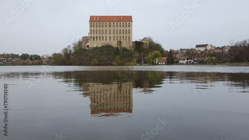 Historical Plumlov castle from 17th century and reflection on the surface of the pond in Prostejov district in Czech republic. Cloudy smoke fog air pollution sky. photo