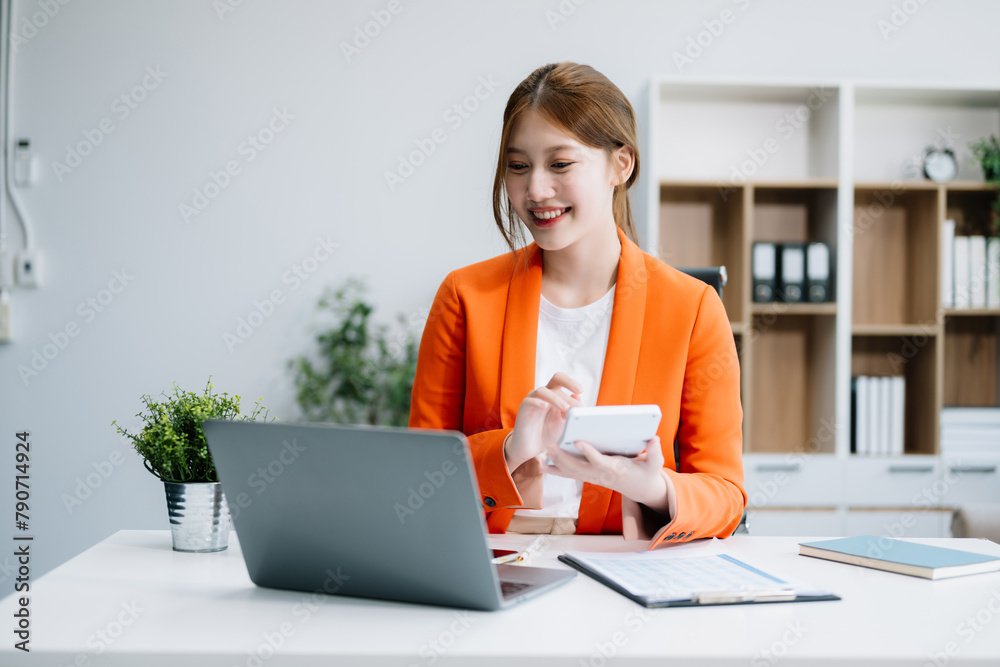 Asian businesswoman working with working notepad, tablet and laptop documents in the office Asian businesswoman working with working notepad, tablet and laptop documents in the office