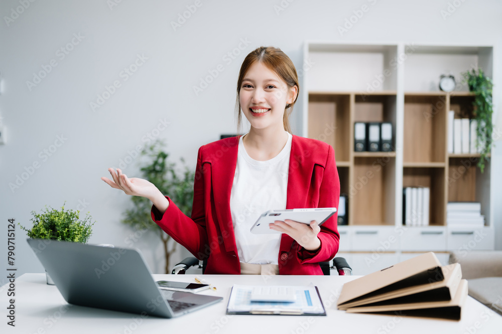 Confident Asian woman with a smile standing holding notepad and tablet at the ffice.. Confident Asian woman with a smile standing holding notepad and tablet at the ffice..