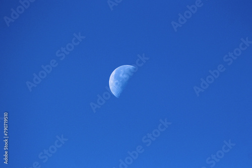 The Moon as Earths only natural satellite clearly visible in its Waning gibbous Moon phase on clear blue sky early in the morning