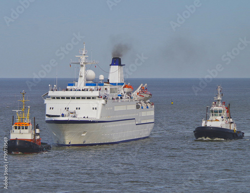Small classic cruiseship cruise ship ocean liner Berlin arrival into Bremerhaven port, Germany with tug boats and marine traffic © Tamme