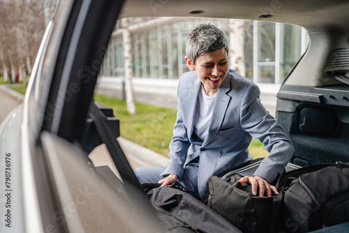 one senior woman pack luggage baggage suitcase in the trunk of the car © Miljan Živković