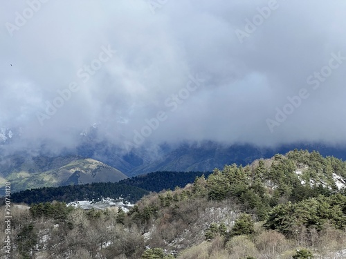 Tseylomsky pass in Ingushetia. A trip uphill to the Tsei Loam pass on a cloudy spring day. Panorama of the high cliffs of the Dzheyrakh gorge. North Caucasus, Russia photo