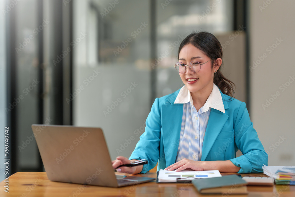 Focused businesswoman working on a laptop at a wooden desk. Professional dedication and business task concept. Focused businesswoman working on a laptop at a wooden desk. Professional dedication and business task concept.