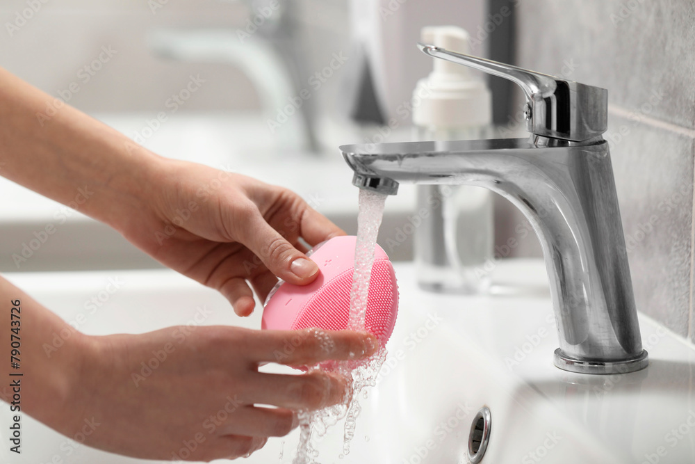 Young woman washing facial brush in bathroom, closeup Young woman washing facial brush in bathroom, closeup