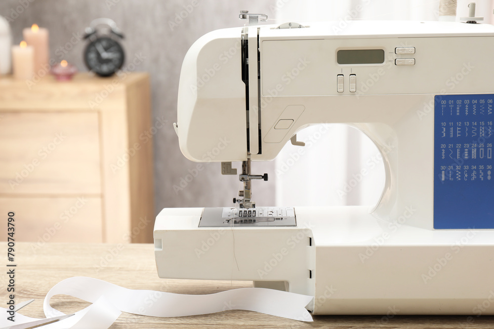 White sewing machine on wooden table indoors