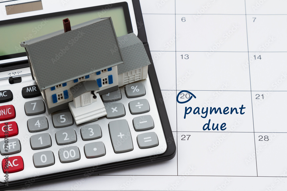 Mortgage payment due with house and calculator on a calendar Mortgage payment due with house and calculator on a calendar