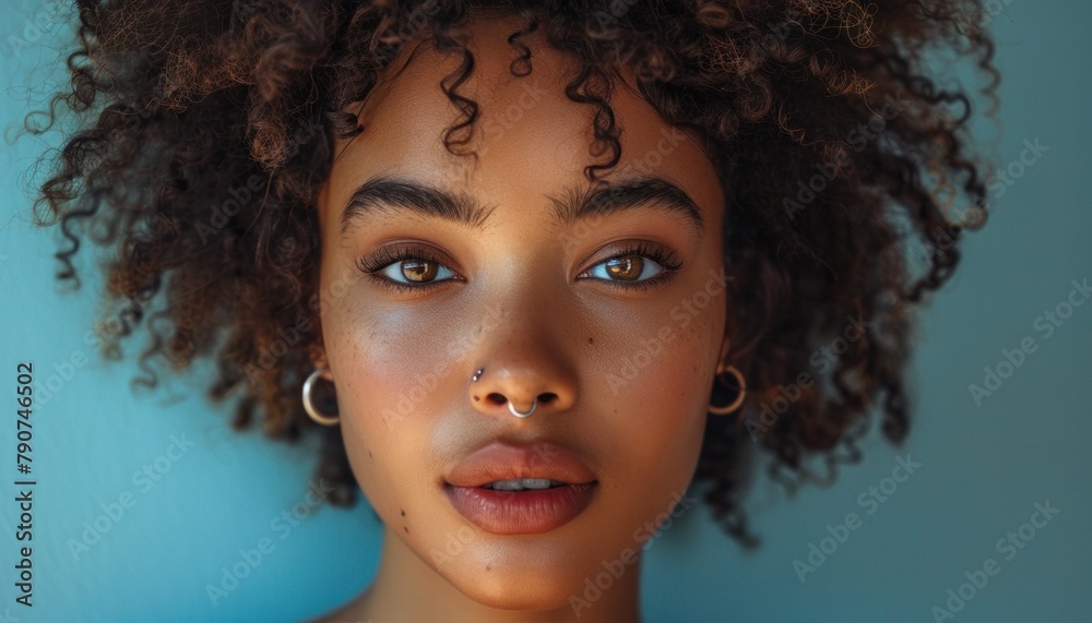 Closeup of womans face with curly hair, earrings, and a bright smile