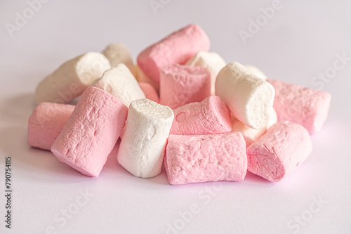 heap of sweet fluffy white and pink marshmallows on white surface close up