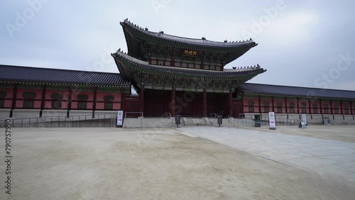 the grand entrance of Gyeongbokgung Palace in Seoul, showcasing traditional Korean architecture with intricate designs and vibrant colors under a cloudy sky photo